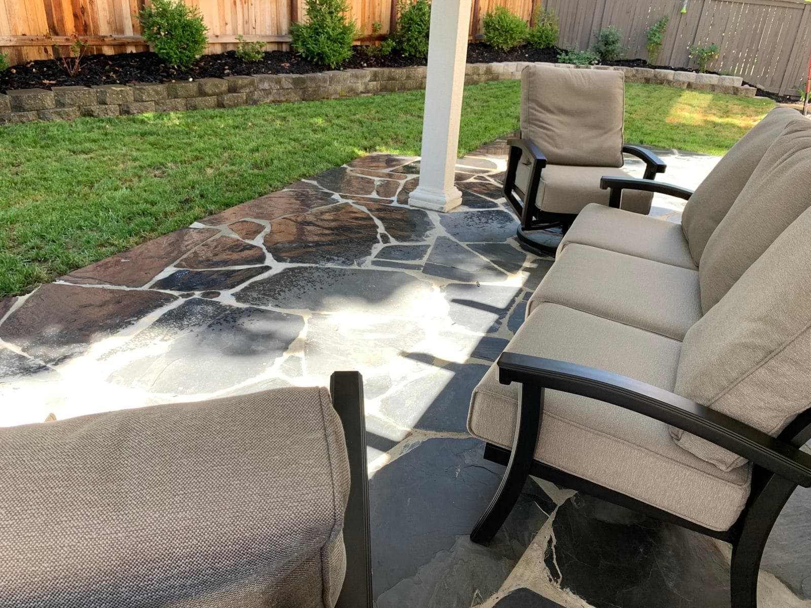 Mortared flagstone patio with hand-cut joints, block-edged planting beds, and new sod lawn
